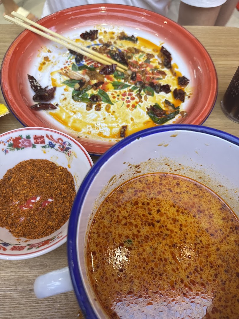 A close-up of a spicy meal with chili powder and soup, showcasing the vibrant flavors.