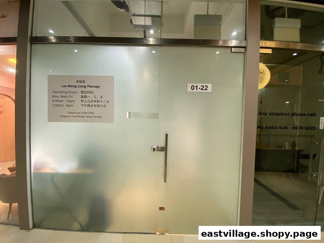 The frosted glass entrance of Lee Meng Liang Therapy, displaying operating hours and contact information.