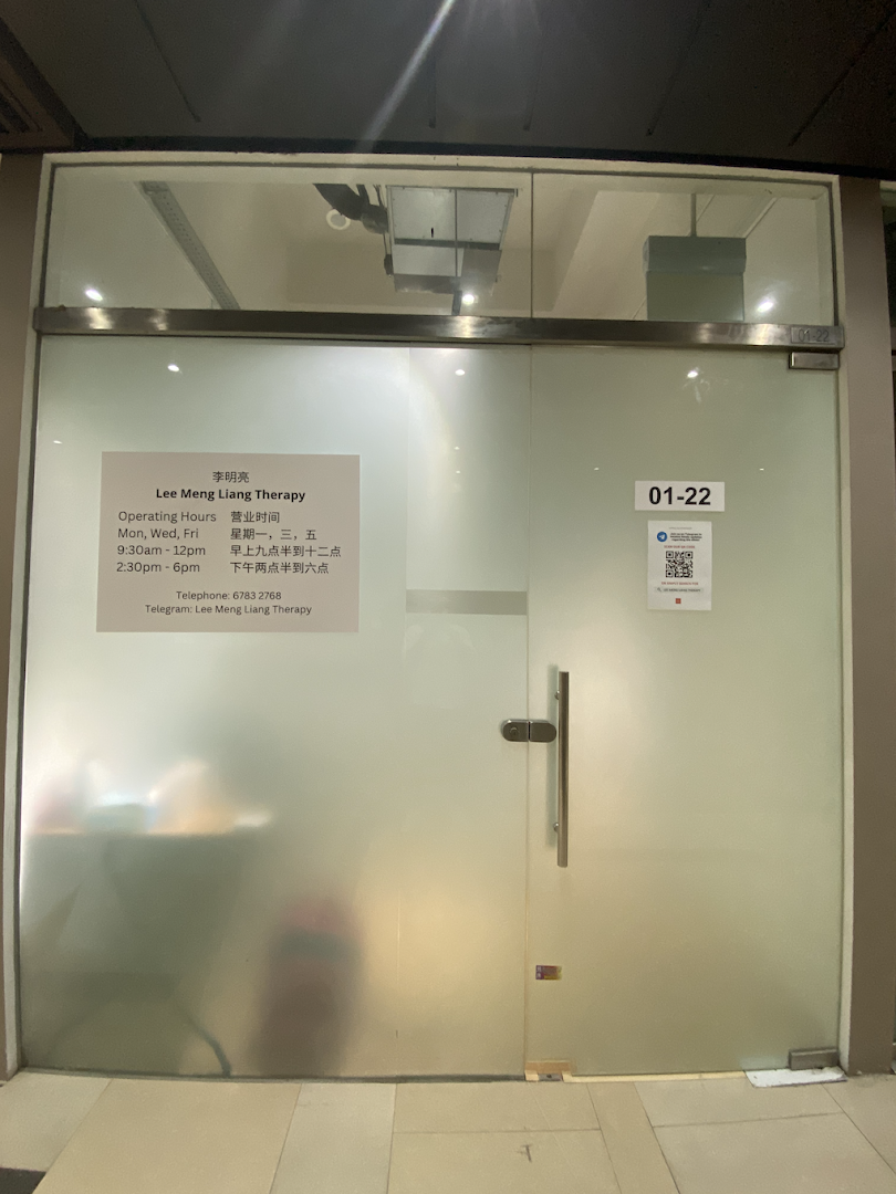 The frosted glass entrance of Lee Meng Liang Therapy, displaying operating hours and contact information.