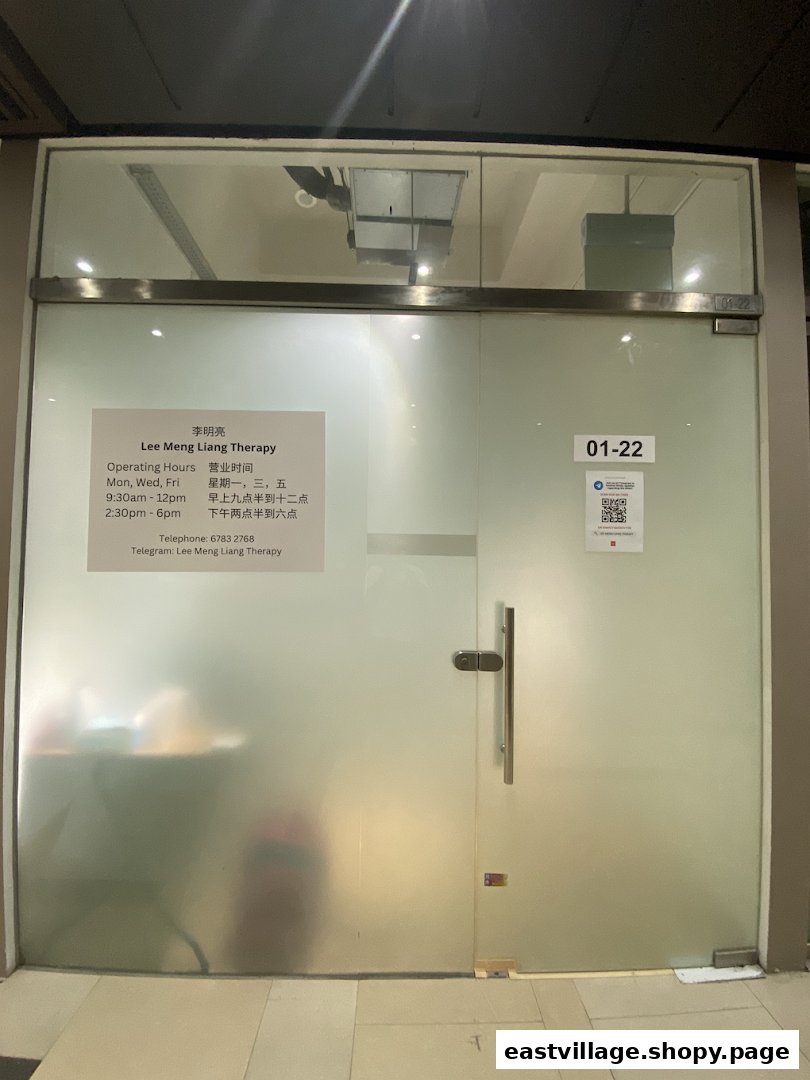The frosted glass entrance of Lee Meng Liang Therapy, displaying operating hours and contact information.