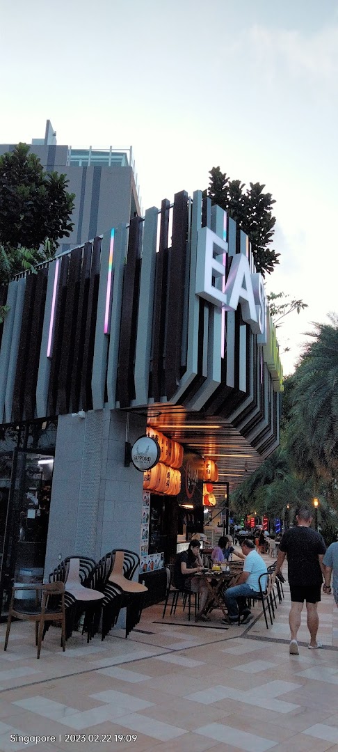 An outdoor view of a modern restaurant or bar with patrons dining al fresco.