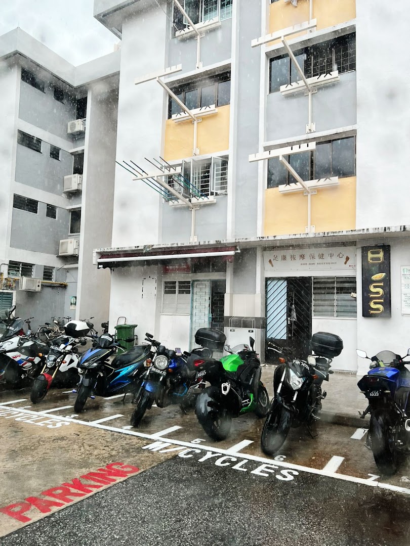 The exterior of Lee Meng Liang Therapy, showing its entrance, building facade, and parked motorcycles.