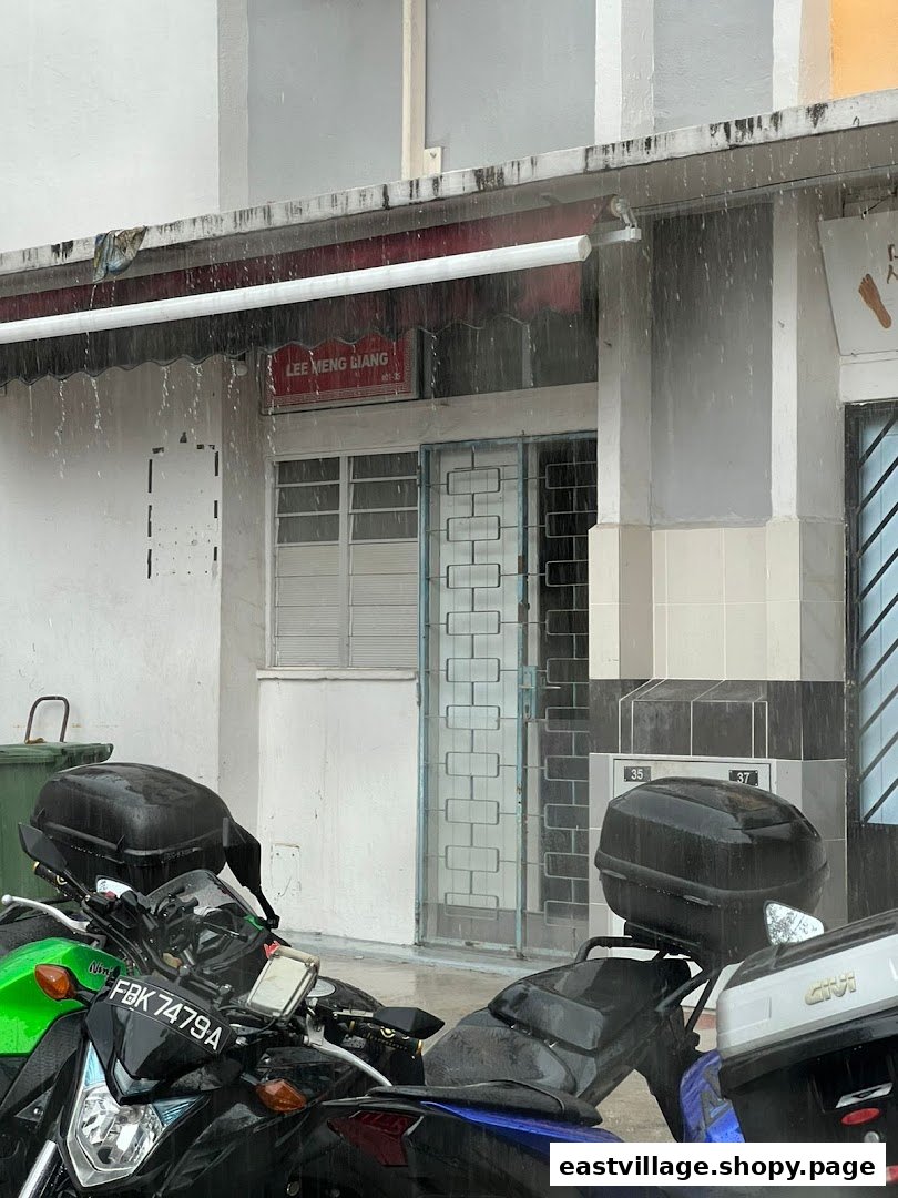 The shop front of Lee Meng Liang Therapy on a rainy day, with motorcycles parked outside.