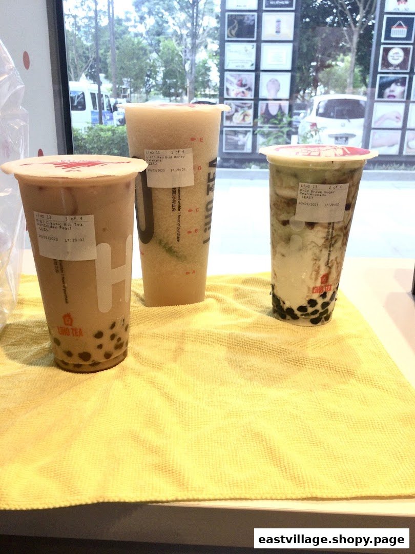 Three refreshing LiHO TEA bubble tea drinks, including milk tea and fruit blends, displayed on a counter.