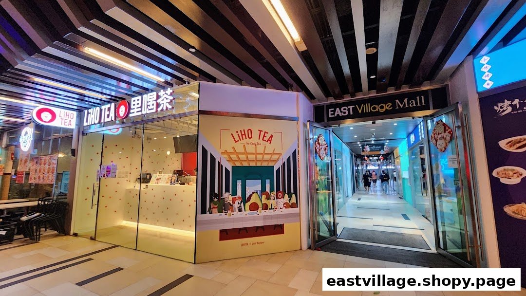 The brightly lit storefront of LiHO TEA next to the entrance of East Village Mall.