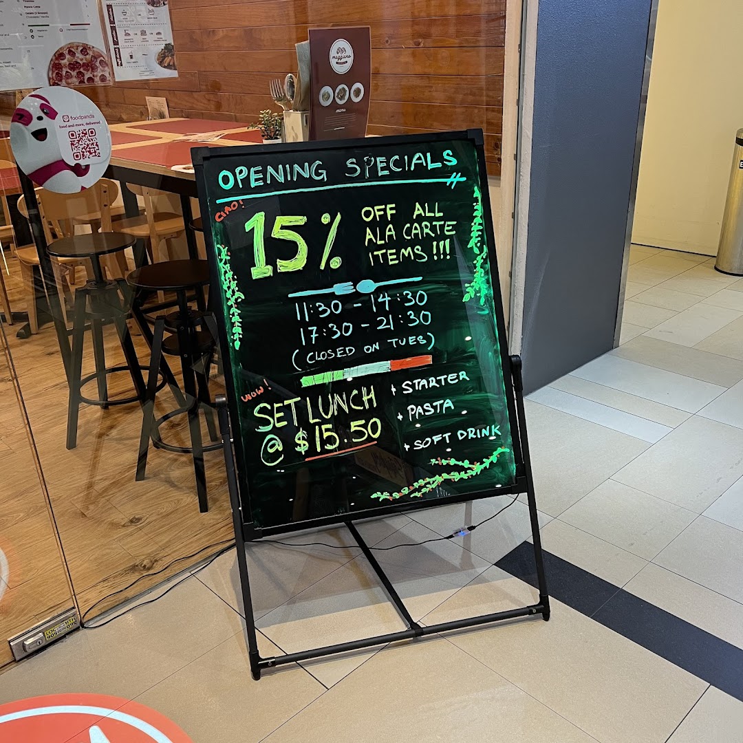 A blackboard sign outside Maggiano's advertises opening specials, including discounts and set lunch offers.