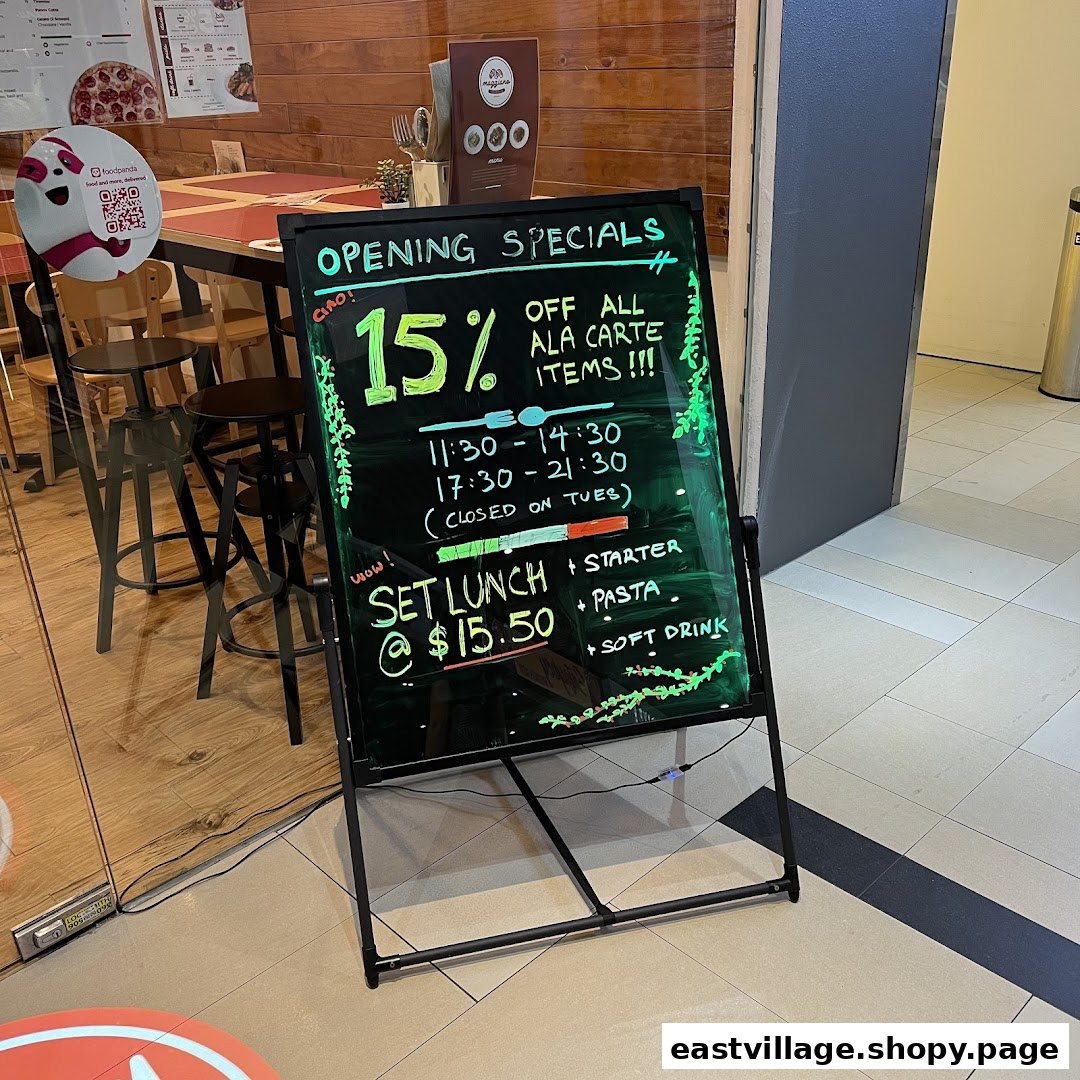 A blackboard sign outside Maggiano's advertises opening specials, including discounts and set lunch offers.