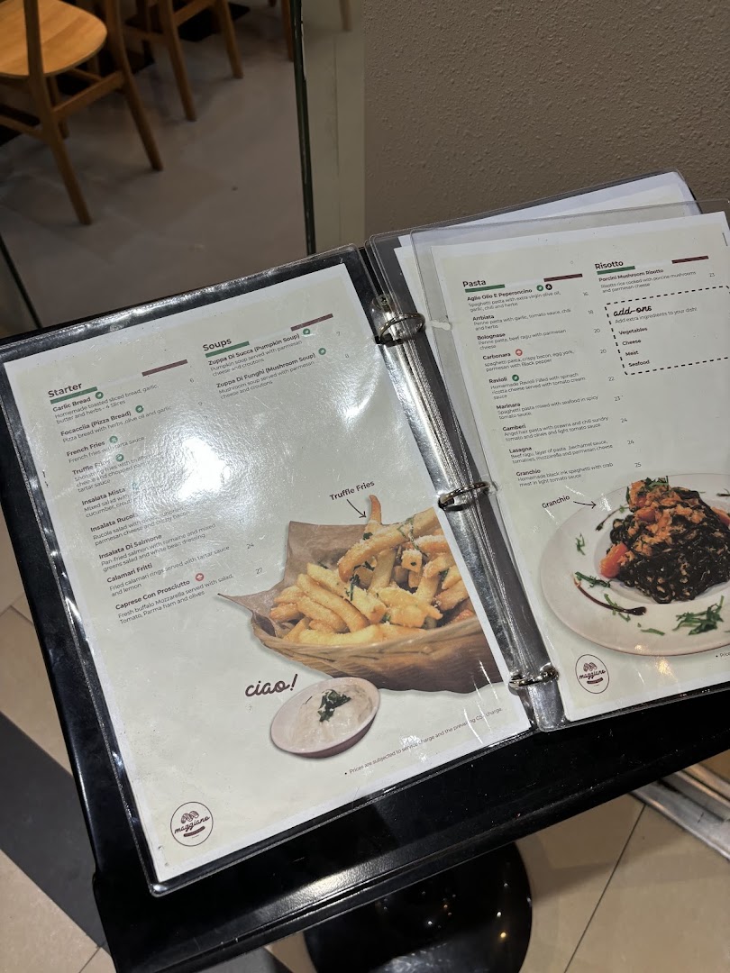 A close-up view of a Maggiano restaurant menu displaying Italian starters, soups, pasta, and risotto dishes.
