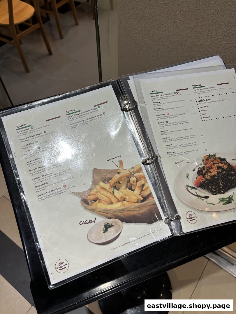 A close-up view of a Maggiano restaurant menu displaying Italian starters, soups, pasta, and risotto dishes.