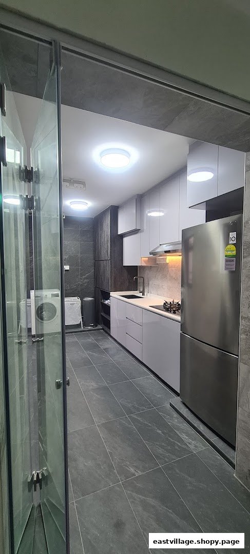 A modern kitchen and utility area featuring sleek cabinetry, dark tiled floors, and integrated appliances.