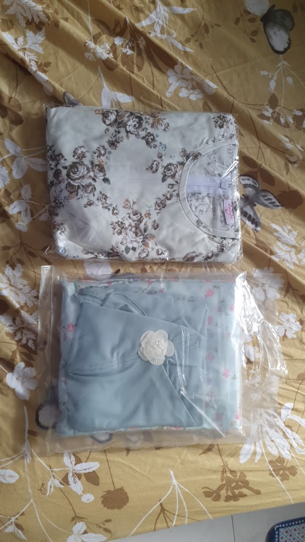 Two neatly packaged clothing items, one floral and one blue, on a patterned surface.