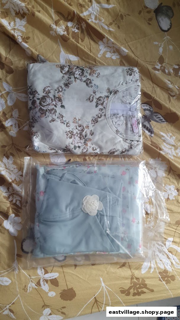 Two neatly packaged clothing items, one floral and one blue, on a patterned surface.