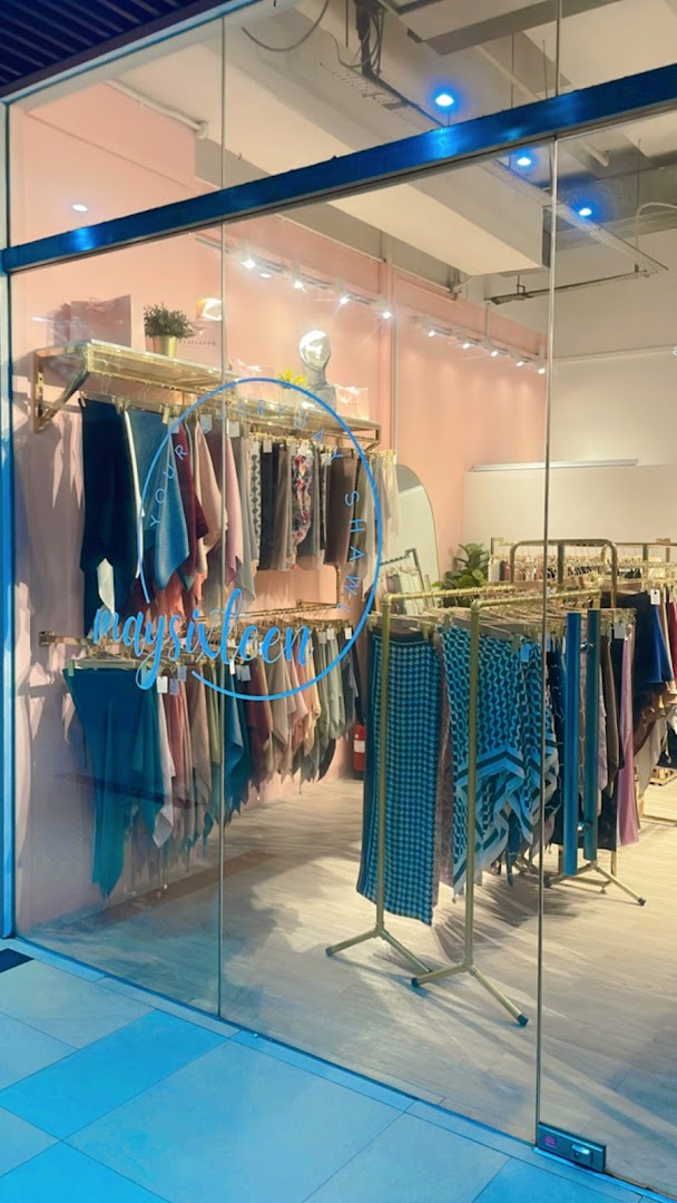 The shop front of Maysixteen, showcasing a variety of colorful shawls and clothing items.