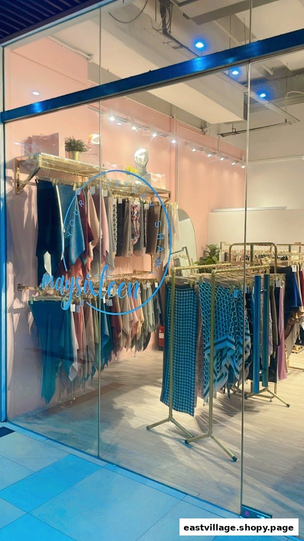 The shop front of Maysixteen, showcasing a variety of colorful shawls and clothing items.