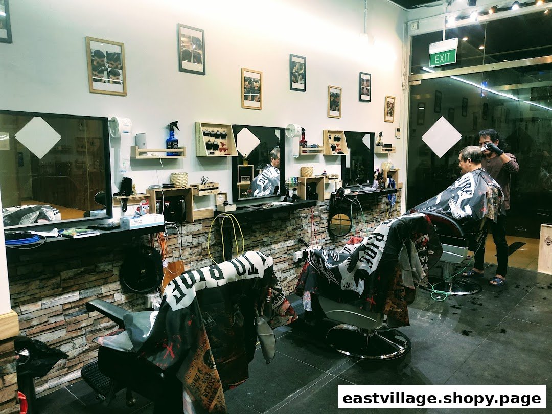 A barber attends to a client in a modern, well-lit barber shop with multiple stations.