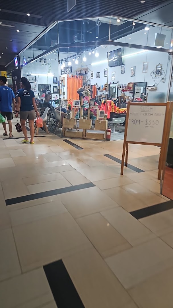 The glass storefront of Mister Guy Barber, revealing its interior with barber chairs and styling stations.