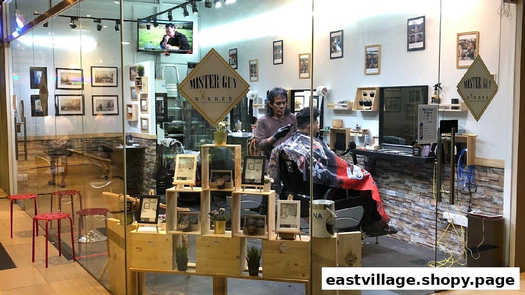A barber is cutting a client's hair inside the Mister Guy Barber shop, visible through a glass storefront.