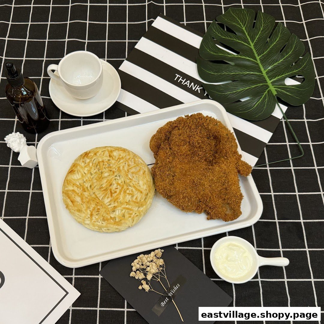 A crispy breaded cutlet and a savory potato pancake served on a tray with sauce and a cup.