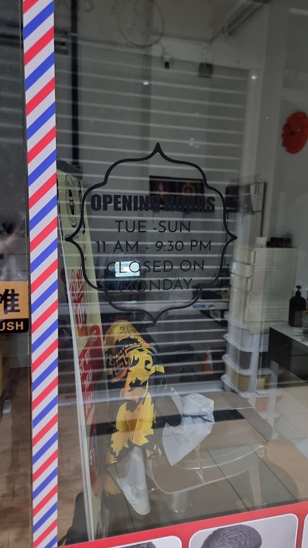 The glass entrance of Murugan Barber Shop displaying its opening hours and a barber pole stripe.