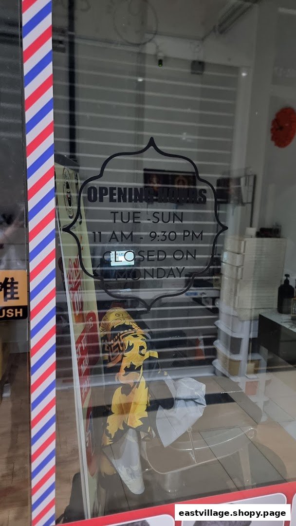 The glass entrance of Murugan Barber Shop displaying its opening hours and a barber pole stripe.