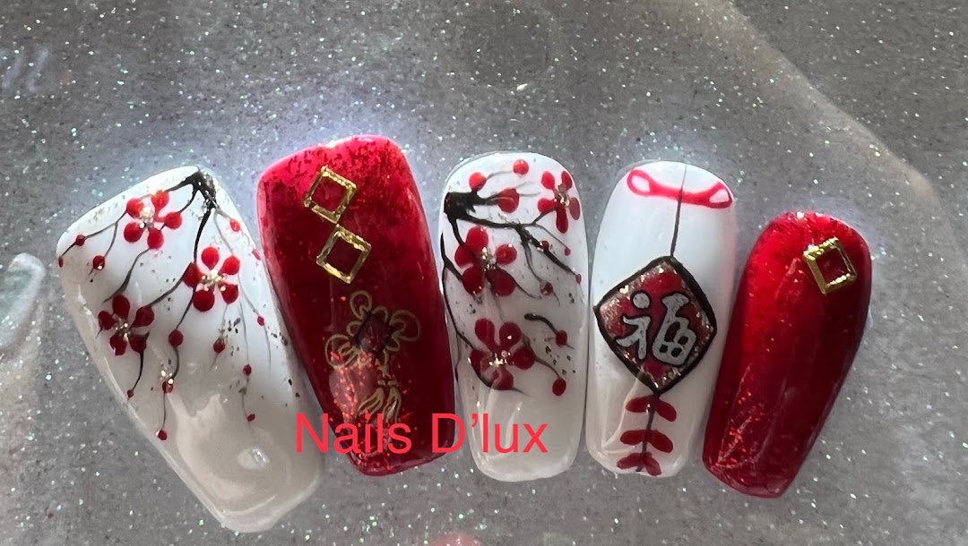 Five artificial nails showcasing intricate red and white designs, including floral patterns and traditional symbols.