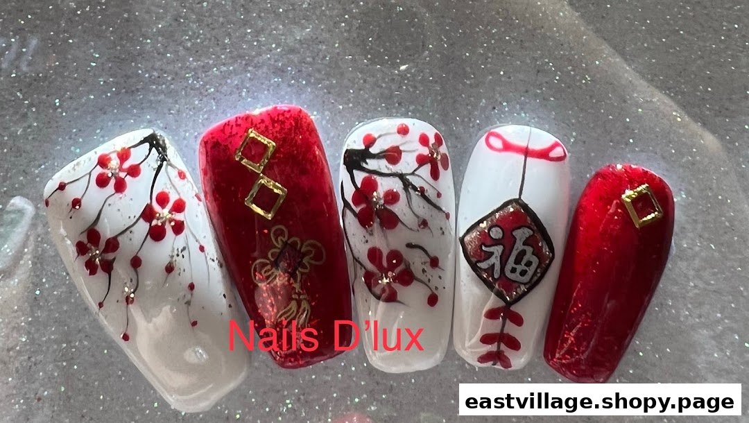 Five artificial nails showcasing intricate red and white designs, including floral patterns and traditional symbols.