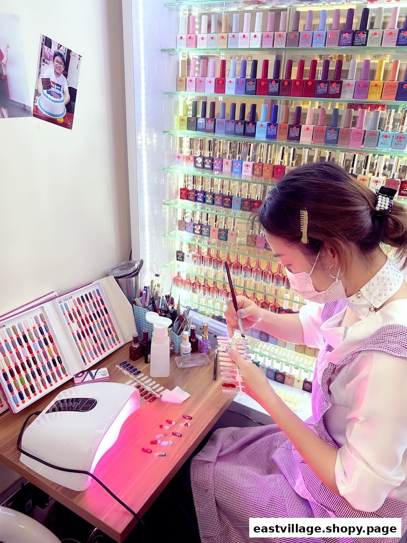 A nail technician meticulously paints nail samples, surrounded by a vibrant display of colorful nail polishes.