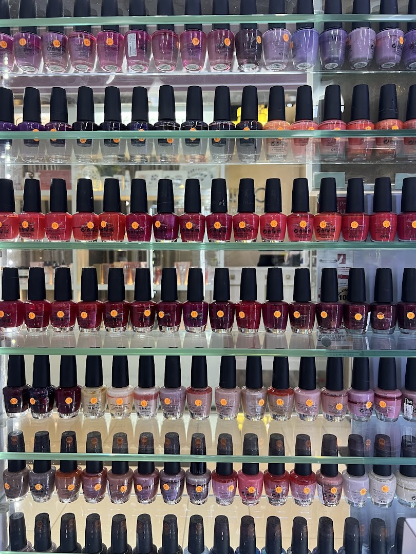 A vibrant display of numerous nail polish bottles in various colors on clear shelves.