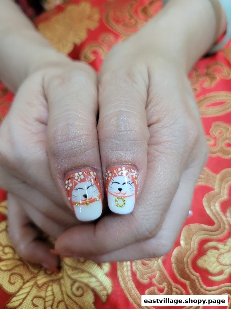 Close-up of hands displaying intricate Maneki-neko cat nail art with gold accents.