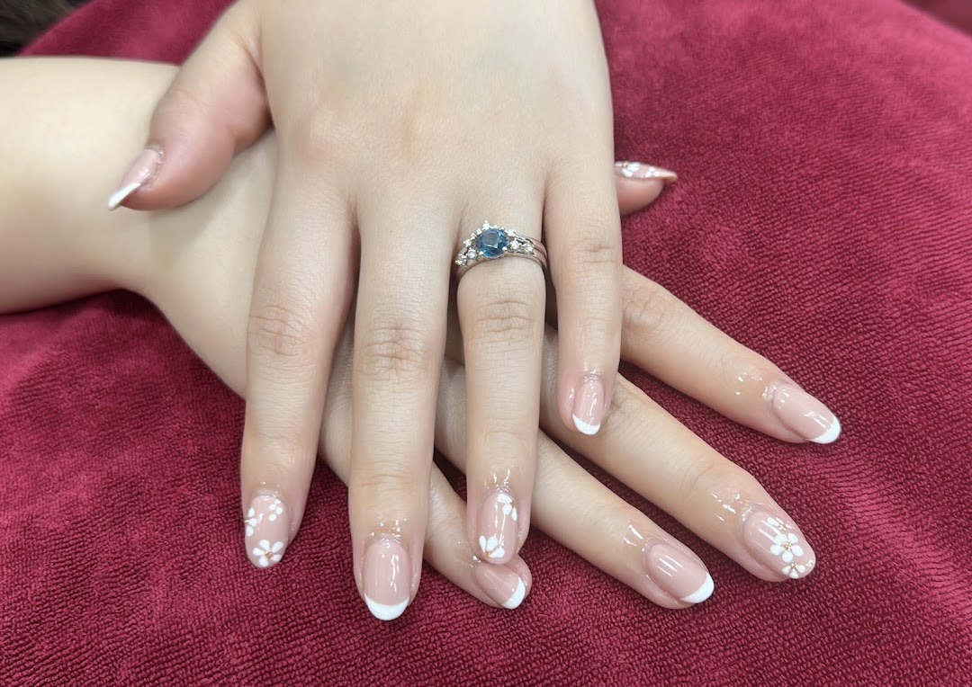 Close-up of hands showcasing an elegant French manicure with delicate white floral nail art.