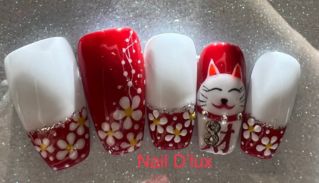 Close-up of five artificial nails featuring red, white, floral, and Maneki-neko designs.