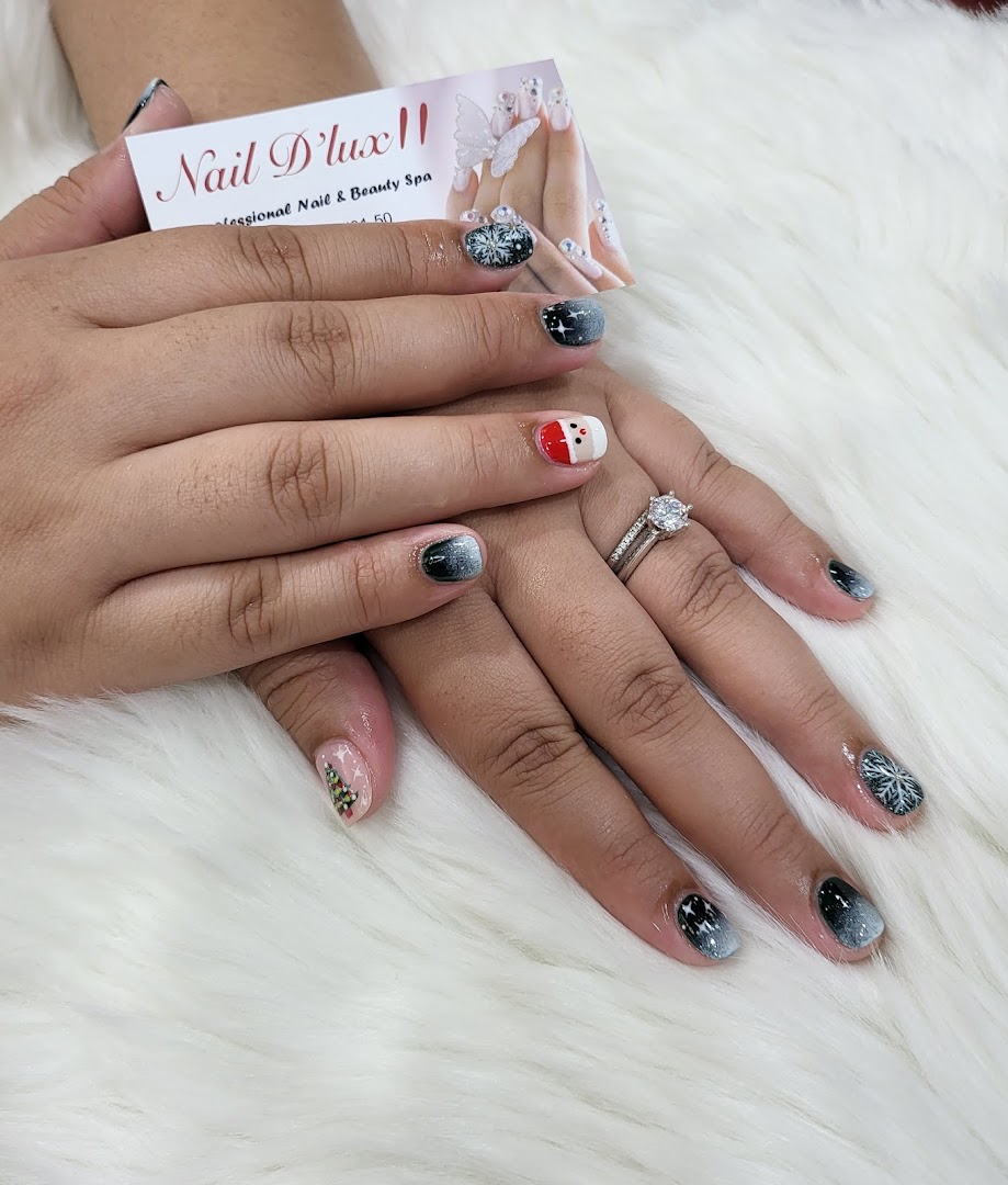 Hands showcasing festive holiday nail art with a Nail D'lux II business card.