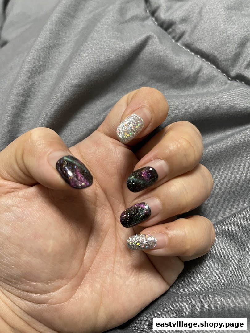A hand showcasing nails with sparkling glitter and iridescent multi-chrome polish designs.