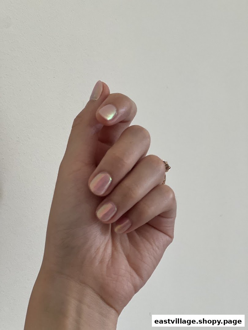 A hand showcasing iridescent, shimmery nail polish, highlighting a fresh manicure.