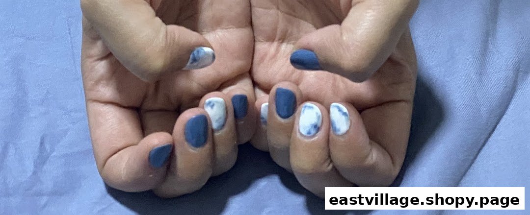 Close-up of hands showcasing a fresh manicure with blue and white marbled nail art.