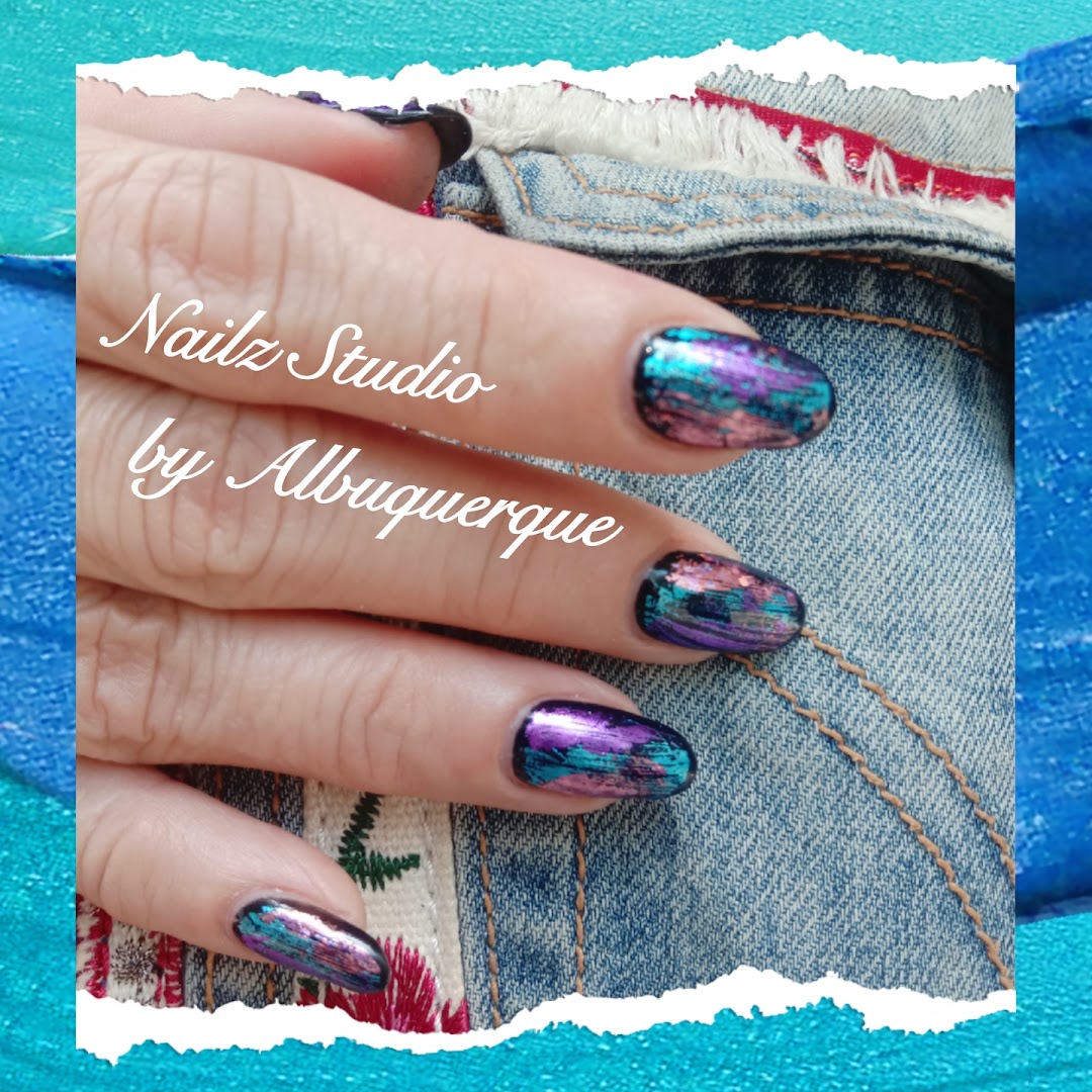 A hand showcasing vibrant, multi-colored nail art with a metallic and iridescent finish.