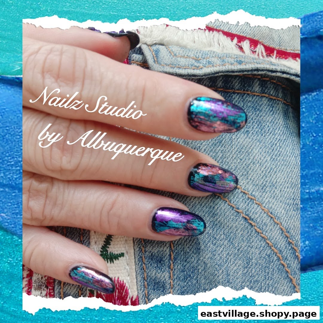 A hand showcasing vibrant, multi-colored nail art with a metallic and iridescent finish.