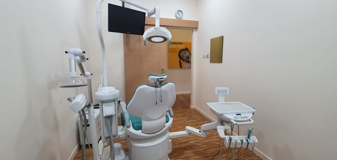A clean and modern dental treatment room with a patient chair and professional equipment.
