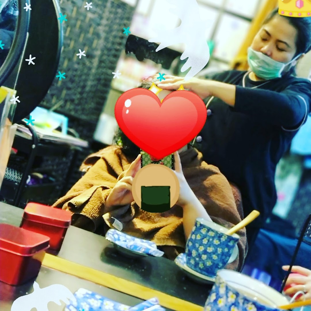 A client receives a relaxing head treatment from a masked therapist at Niki Beauty Wellness Salon.