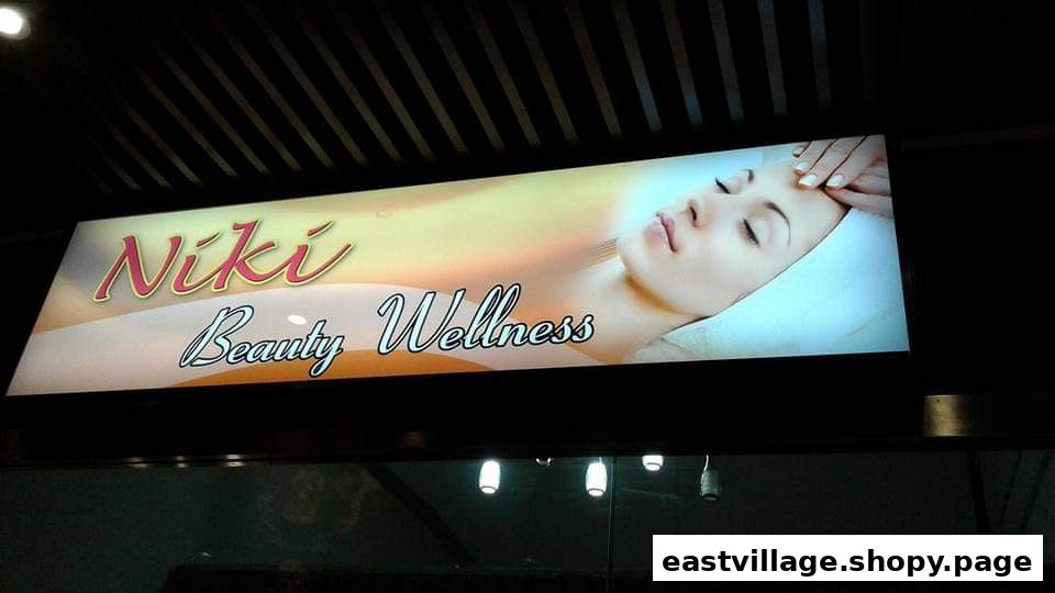 An illuminated sign for Niki Beauty Wellness Salon and Spa, featuring a woman receiving a facial.
