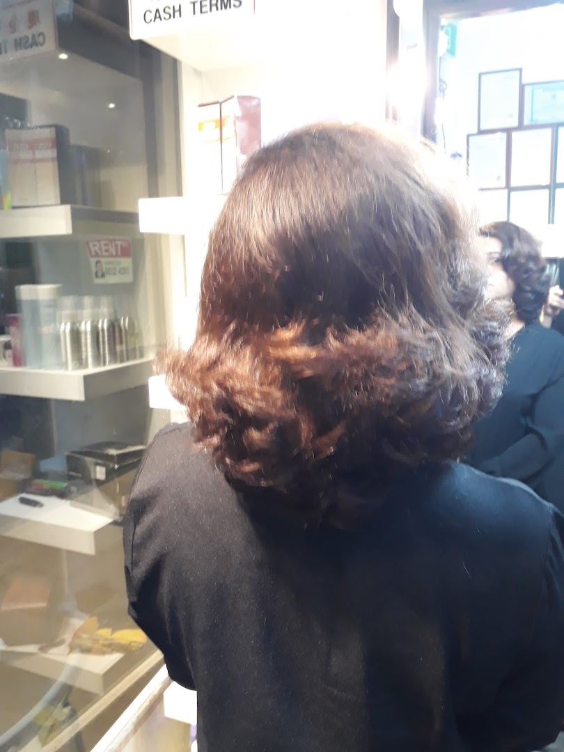 A client's back view inside Niki Beauty Wellness Salon, showcasing the salon's interior and products.