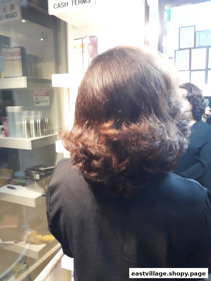 A client's back view inside Niki Beauty Wellness Salon, showcasing the salon's interior and products.
