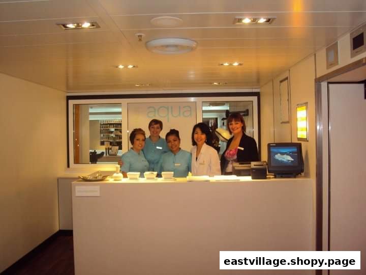 Five friendly staff members at the reception desk of a modern beauty and wellness salon.
