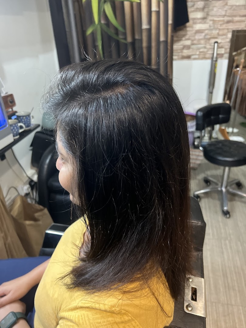 A client seated in a salon chair, showcasing hair treatment or styling in progress.