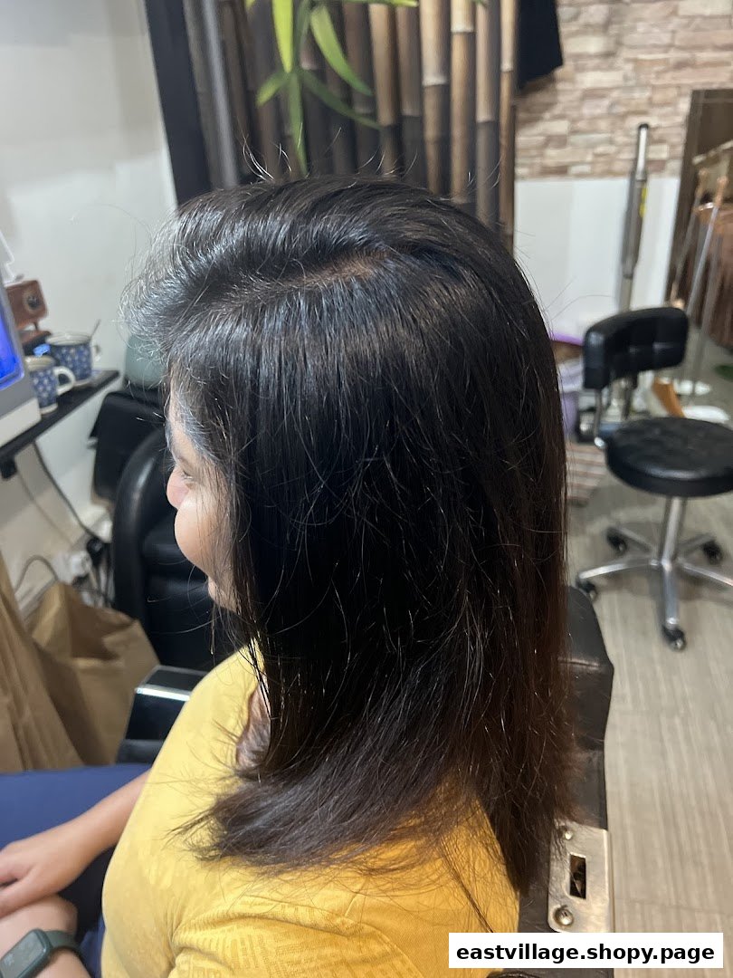 A client seated in a salon chair, showcasing hair treatment or styling in progress.