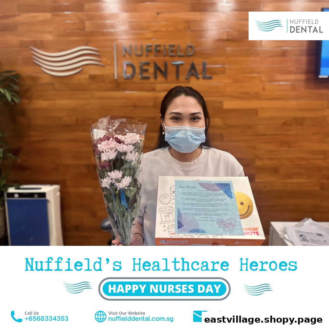 A masked Nuffield Dental staff member holds flowers and a Dunkin' Donuts box, celebrating Nurses Day.