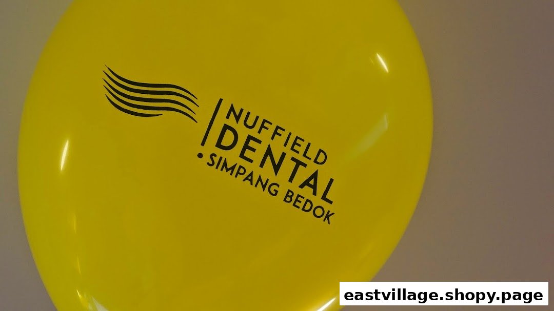 A bright yellow balloon featuring the Nuffield Dental Simpang Bedok logo.