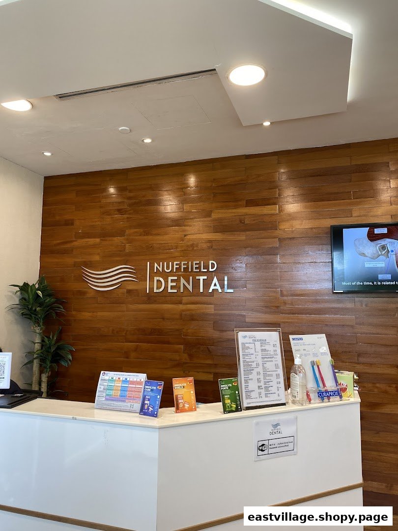 The modern reception desk of Nuffield Dental with a wooden feature wall.