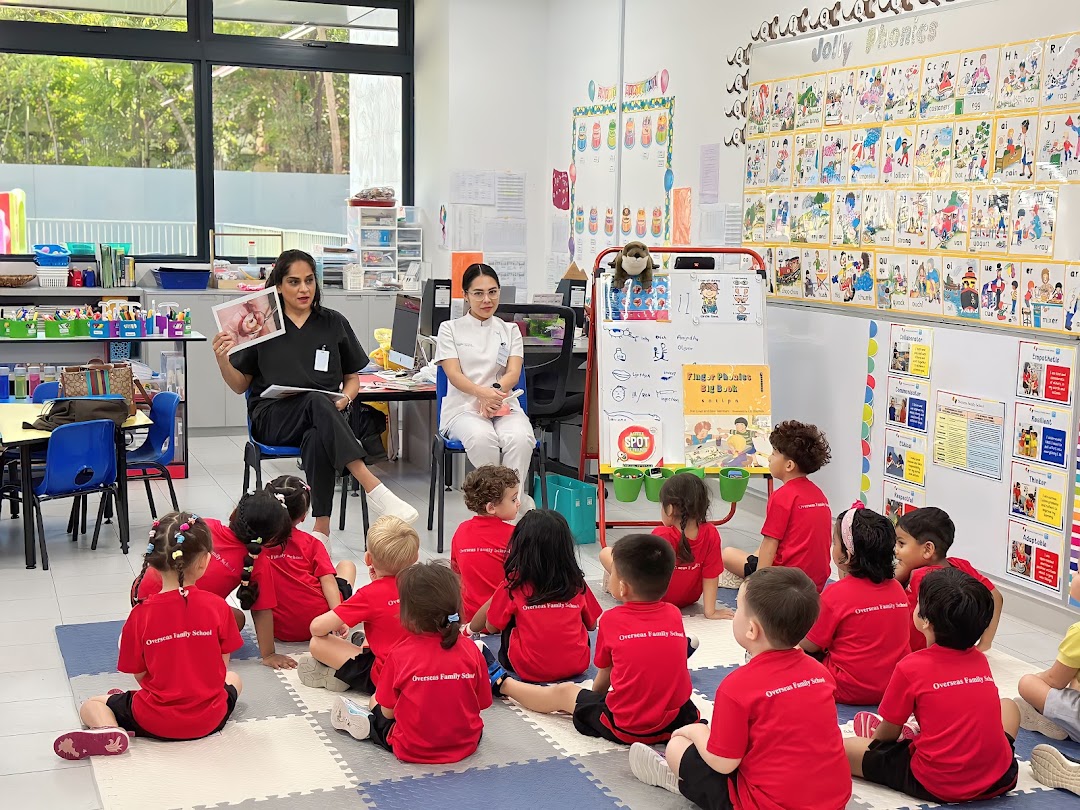 Dentists engage children in a classroom setting, likely teaching about dental health.