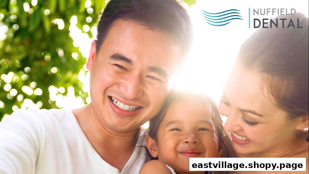 A happy family, including a father, mother, and child, smiling brightly with the Nuffield Dental logo.